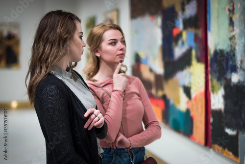 two girls discuss paintings in Gallery of contemporary art