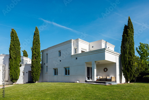 Modern house with spacious lawn and clear blue sky
