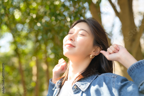 Konstfotografi 目を閉じて春の光と自然を全身で感じる女性のリラックスしたポートレート
