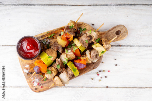 Grilled skewers with meat and vegetables. Delicious roasted beef meat, champignon mushrooms, zucchini, tomato, onion on wooden sticks, summed balanced appetizers for picnic and bbq