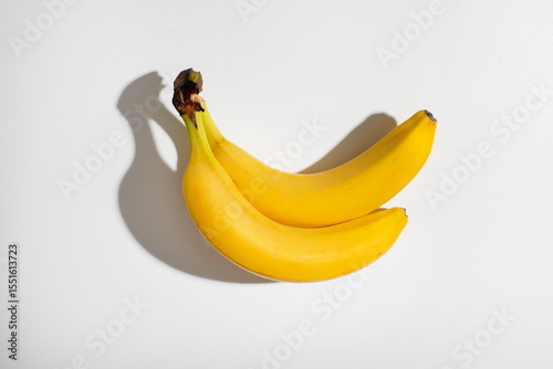 Golden crescent bananas entwined under a spotlight, resonating tropical fiesta vibes for National Banana Lovers Day and quirky fruit symbolism