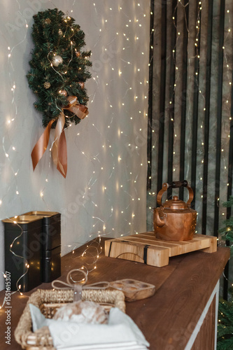 Home New Year's kitchen interior. Decorations with garlands and a Christmas wreath. Cozy atmosphere of a home holiday, loft-style interior design, Scandinavian style.