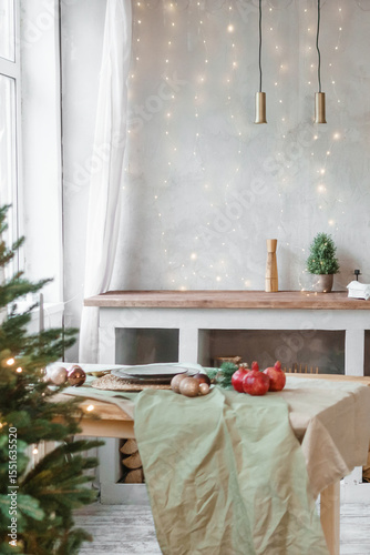 Home New Year's interior. Christmas tree with gifts, decorated with garlands in the kitchen. Cozy atmosphere of a home holiday, loft design of the room, Scandinavian style.