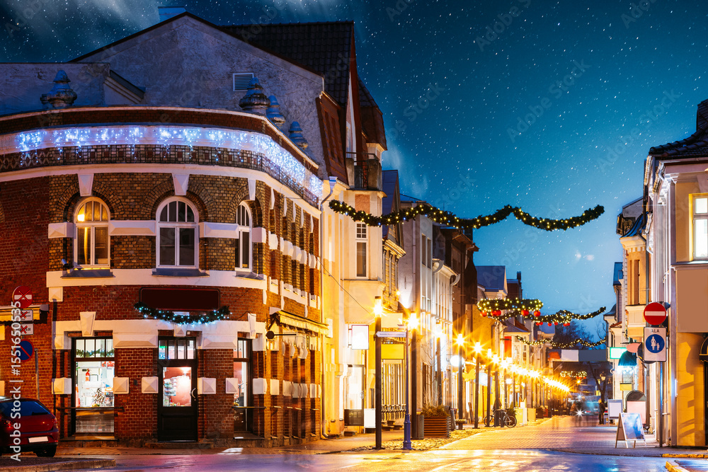 Fototapeta premium Parnu, Estonia. Night View Of Famous Ruutli Street With Old Buildings, Restaurants, Cafe, Hotels And Shops In Festive Evening Night Christmas Xmas New Year Illuminations