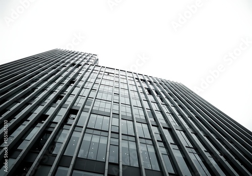 Modern skyscraper building with glass windows against a white sky