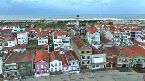 Aerial drone sideways panning of colourful houses along Costa Nova do Prado beach, Portugal