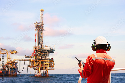 Technician monitor and command by radio to operator on job site in oil and gas industry, Worker in oil and gas industry contact to operation team to check condition of the machine, Maintenance work.
