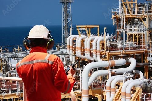 Technician monitor and command by radio to operator on job site in oil and gas industry, Worker in oil and gas industry contact to operation team to check condition of the machine, Maintenance work.