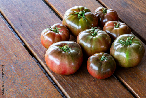 Cherokee Purple tomatoes on wooden table.