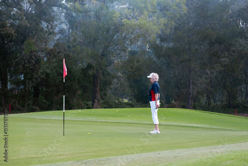 senior woman looking at the final hole at a golf course