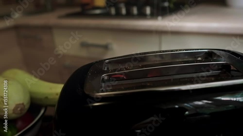 Breakfast is being prepared fresh toast in the toaster with light smoke creating a sense of home comfort and morning warmth