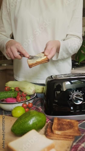 Young woman puts slices of bread into toaster for quick and tasty breakfast easy morning routine with homemade toasted meal