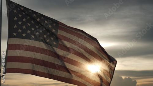 Close up USA American flag waving in the sky against sunset, sunrise outside background. Concept Fourth of July, 4th of July, Independence Day, Veteran Day, Holiday, Celebration. Freedom, Celebration