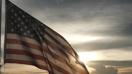 Close up USA American flag waving in the sky against sunset, sunrise outside background. Concept Fourth of July, 4th of July, Independence Day, Veteran Day, Holiday, Celebration. Freedom, Celebration