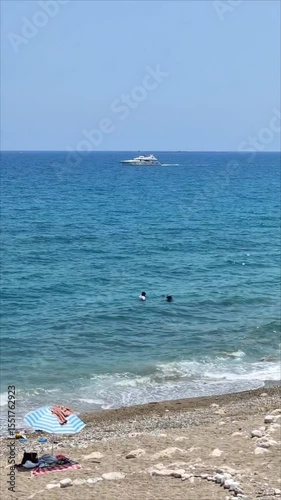 Panorama of the gulf of the Mediterranean Sea with blue water with waves, with a shore with green vegetation, in summer