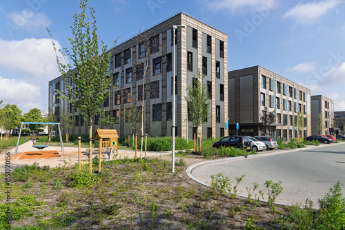 Modern modular housing in Utrecht, Netherlands, featuring multi-story temporary apartments with a playground nearby, addressing urban housing shortages.