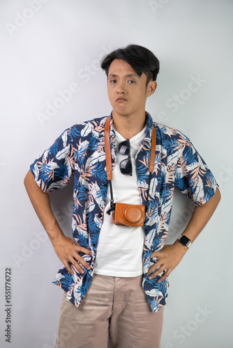 Young asian man wearing blue summer shirt is sulking and disappointed face expression gesture, isolated over white background.	
