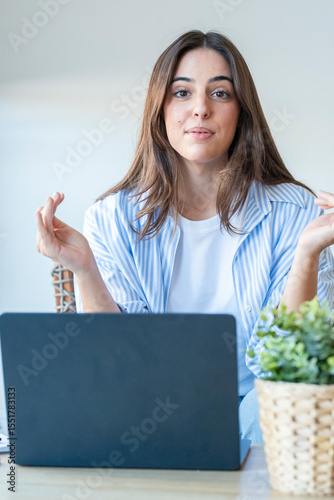 Confident young woman speaking to the camera while sitting at a desk with her laptop. Friendly and professional attitude, ideal for software demos, product reviews, tutorials, or remote presentations