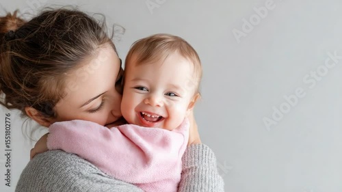 Caring Embrace: A tender moment captured as a mother lovingly embraces her smiling baby, radiating warmth, love, and pure joy. 