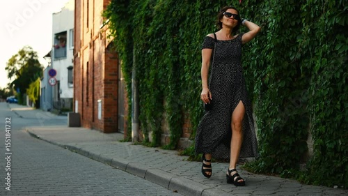 Stylish Young Woman In Sunglasses Strolls Through The Historical Part Of A European City