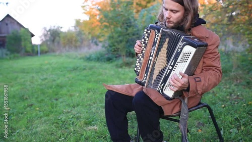 a man plays the accordion in the garden