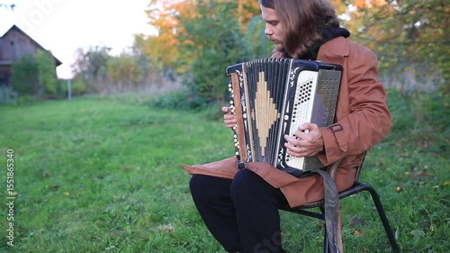 a man plays the accordion in the garden