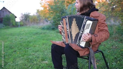 a man plays the accordion in the garden
