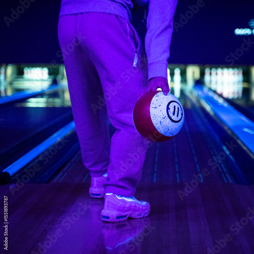 Teenager playing bowling with friends in the evening