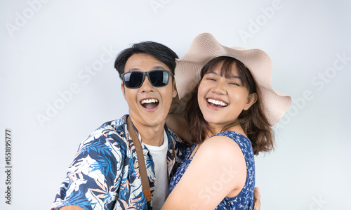 Happy young Indonesian tourist couple in summer clothes is taking selfie photo during holiday season, isolated on white background