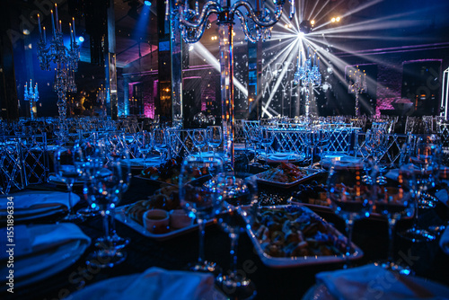 Bilde på lerret Luxurious banquet hall with crystal chandeliers and meticulous table settings under blue lighting