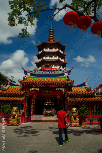 An Asian Man walking toward entrance gate of Tua Pek Kong Temple.  The oldest Chinese temple in the Sibu, Malaysia