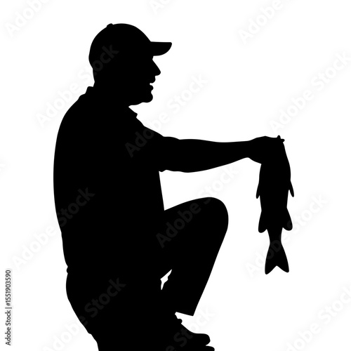 Fisherman holding a large fish while crouching in silhouette  
