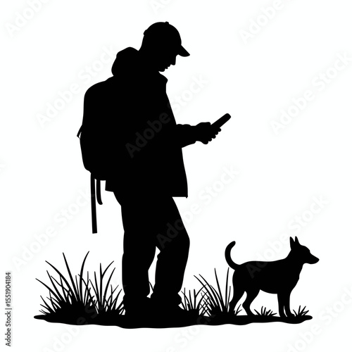 Man standing with dog and using mobile phone in grass silhouette  