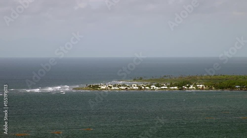 Tobago island landscape with small houses, tropical trees and the Caribbean Sea.