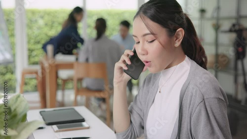 Real estate agent female asia people go green net zero waste control ESG audit office desk. Young adult woman asian SDGs auditor busy happy work using mobile phone call advice stock trader specialist.