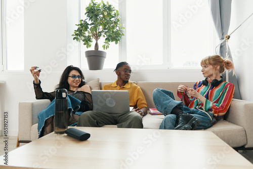 Fototapet Young adult woman coworkers socializing and working together in a modern workplace, showcasing business collaboration and Gen Z friends connecting in a casual office setting