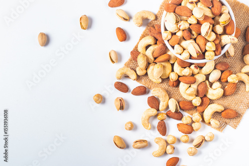 Large assortment of nuts in different bowls on stone table.