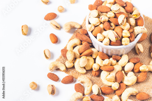 Large assortment of nuts in different bowls on stone table.