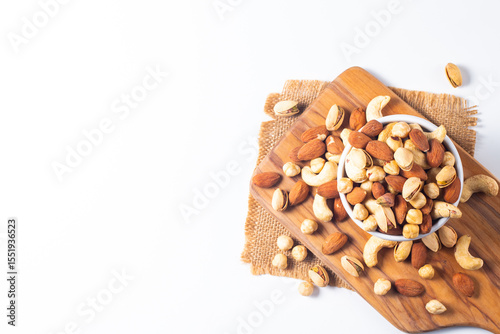 Large assortment of nuts in different bowls on stone table.