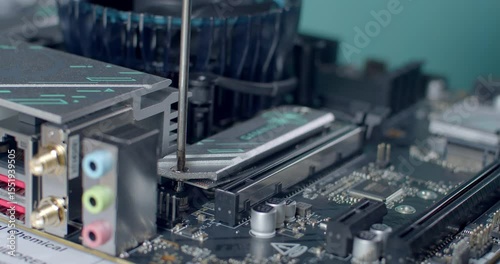 Tightening the screw after mounting the M.2 SSD heatsink.The final step of SSD installation: securing the heatsink with a screw to ensure proper heat management and solid placement.