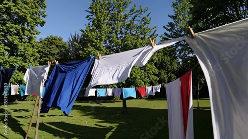 Hanging freshly washed clothes in a sunlit garden on a bright afternoon