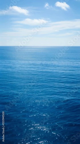 Wallpaper Mural Vast expanse of calm blue ocean meets a clear sky with soft clouds on the horizon, evoking serenity and the immense beauty of nature, ideal for travel visuals and environmental themes Torontodigital.ca