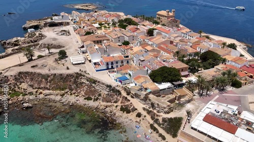 Tabarca Island with San Pedro y San Pablo church and coastal buildings along a vast blue sea