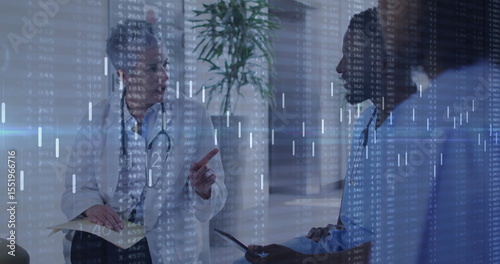 Gesturing doctor consulting patient in clinic hallway, with stethoscope, clipboard and tablet