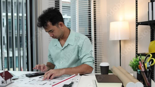 an architect is working in his office, a chief architect is reviewing the design plans before construction begins, an architect brings in blueprints and a model of a house to check for accuracy