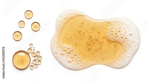 Bubbles scatter across the surface of thick golden gel, all set against white