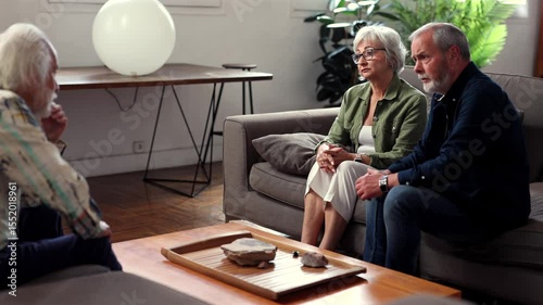 Compassionate senior husband providing emotional support during psychological counseling, holding wife's hand while she shares deeply personal struggles with mental health professional