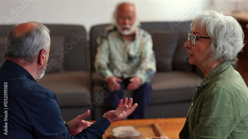 Mature married partners discussing relationship challenges with professional therapist during intimate counseling session, sitting together in comfortable living room environment