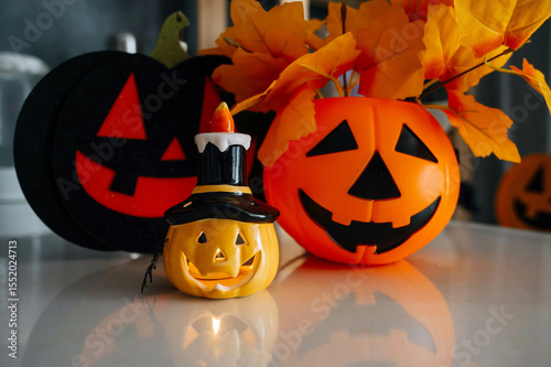 Happy Halloween. Kitchen decoration for Halloween. Pumpkin, funny lamp on the table.