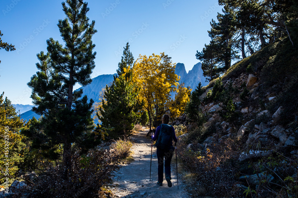 Fototapeta premium Young hiker woman in autumn in Aiguestortes and Sant Maurici National Park, Spain